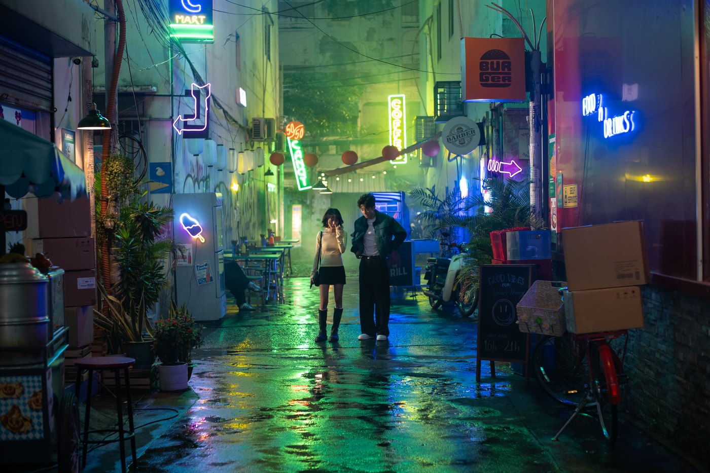 Crew filming at night in a neon-lit alley with wet streets for a Samsung Galaxy S24 film