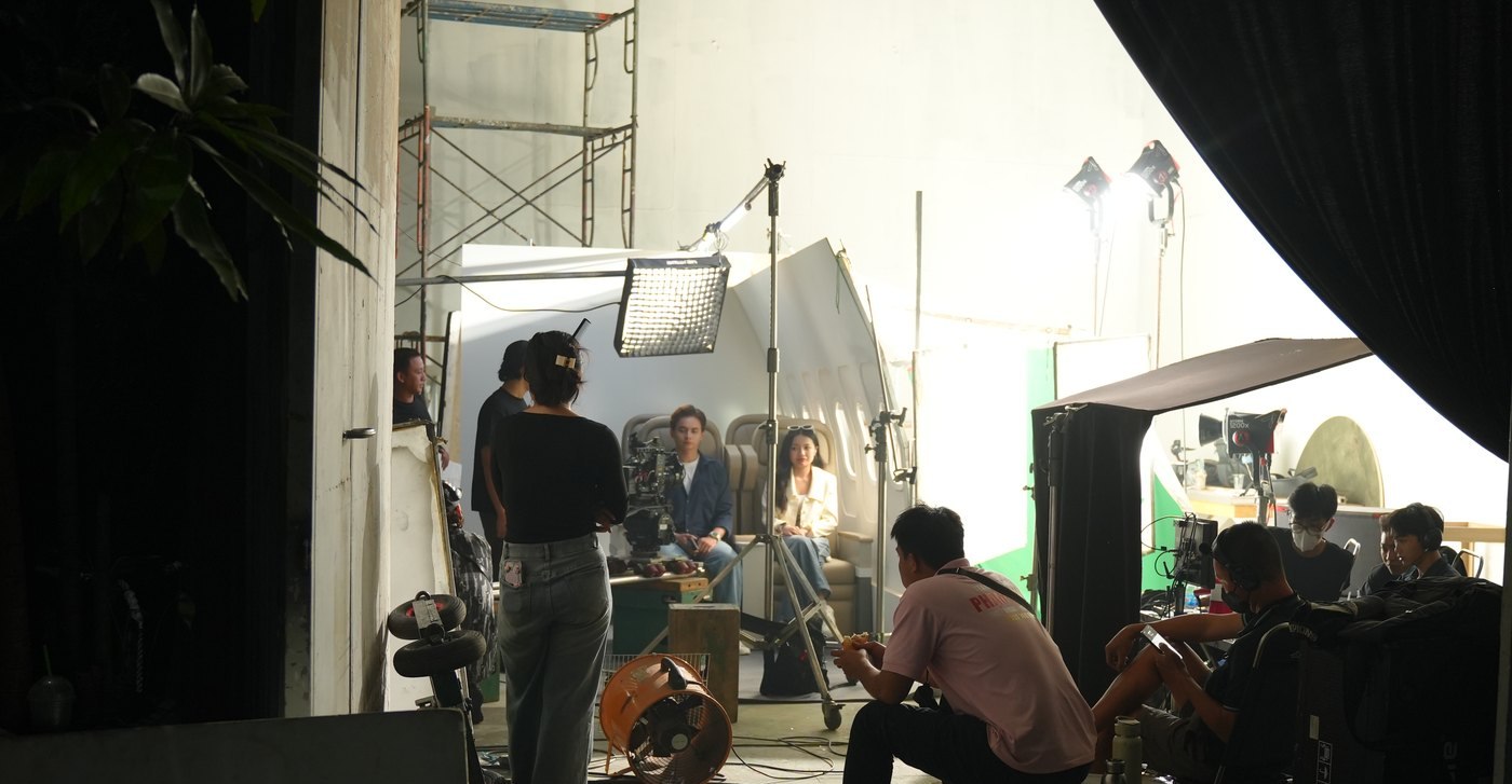 Crew working inside a studio built as an aircraft cabin for a Samsung Wallet film