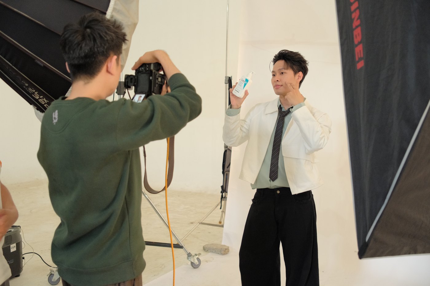 Stills photographer shooting a talent in a white studio during a CeraVe shoot