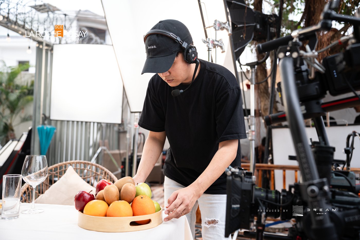 Crew member arranging a bowl of fruit as a prop on a La Roche-Posay set