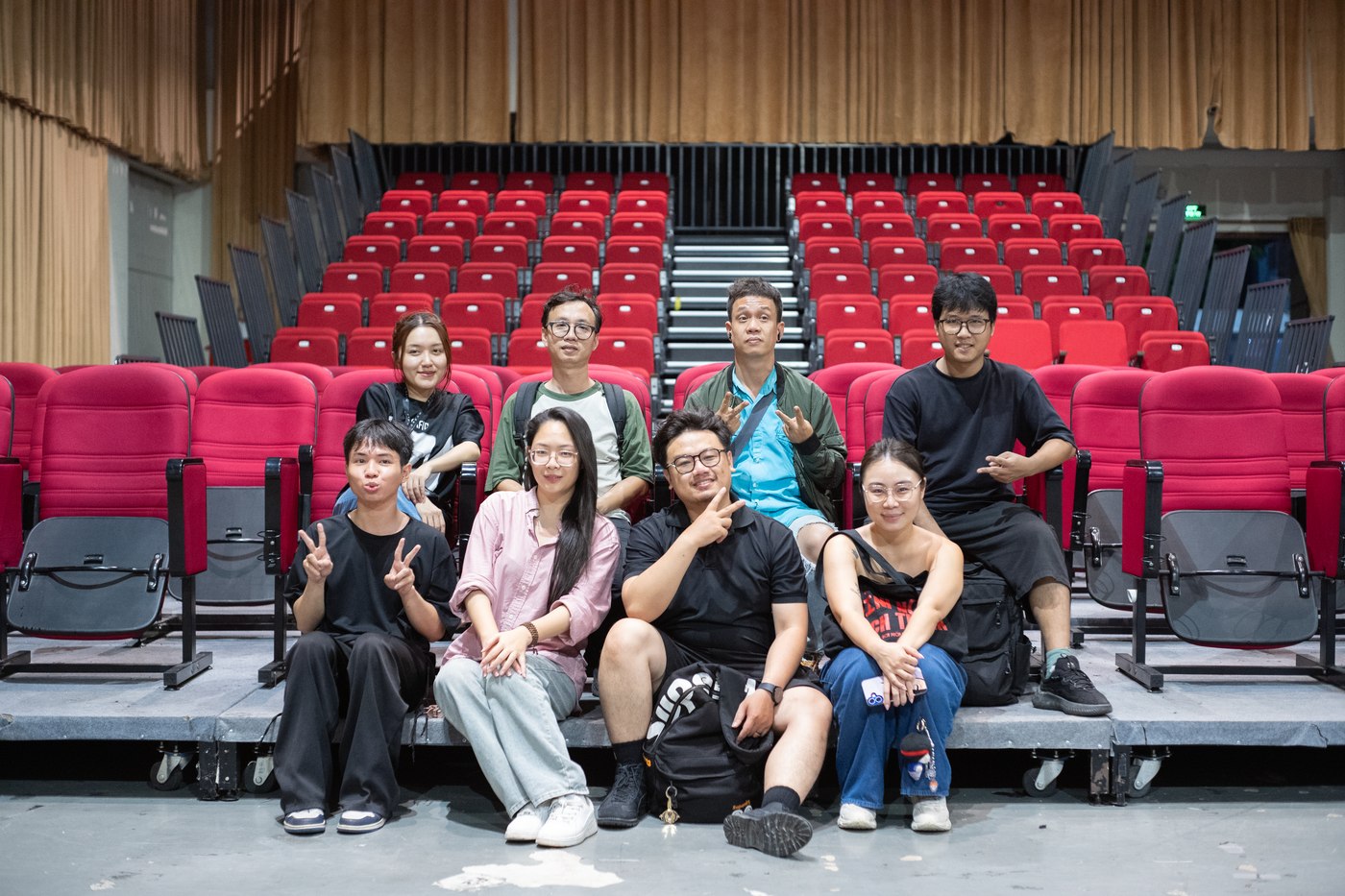 Part of the crew sitting together on the stage steps of an empty auditorium during a Samsung Galaxy A56 shoot
