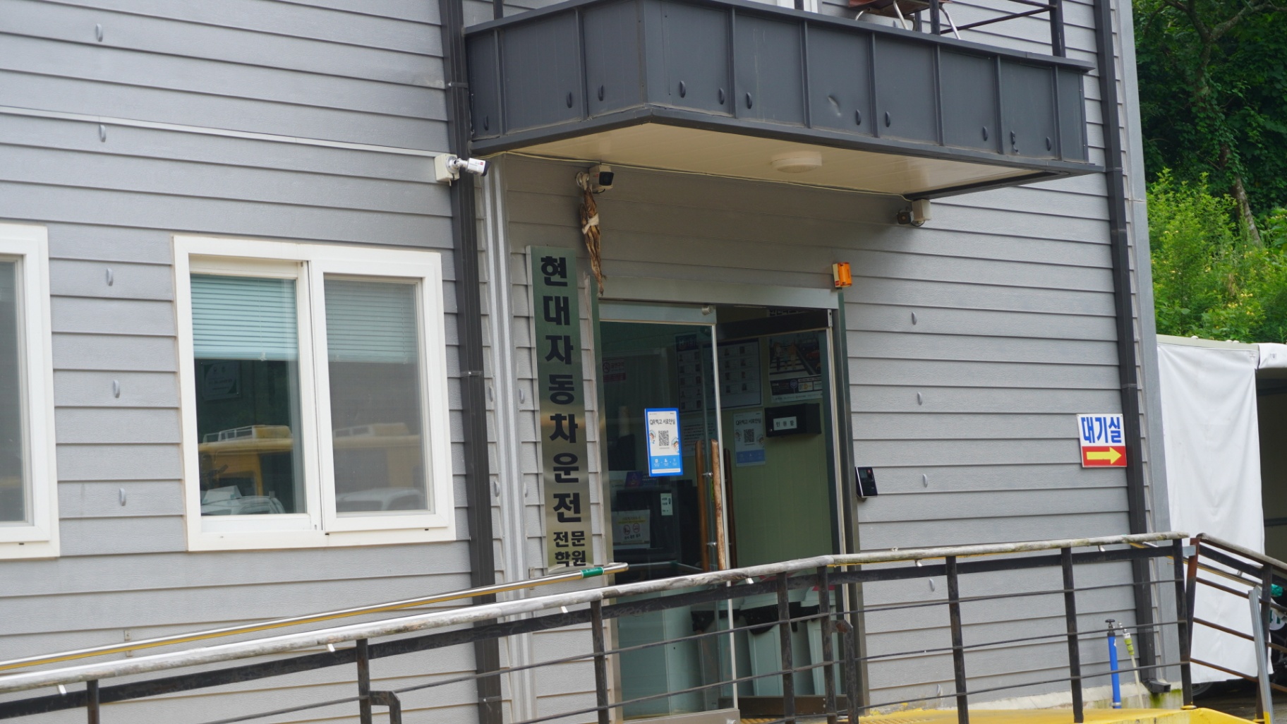 친절한 강사와 함께 도로주행 교육을 받고 있는 수강생의 밝은 모습