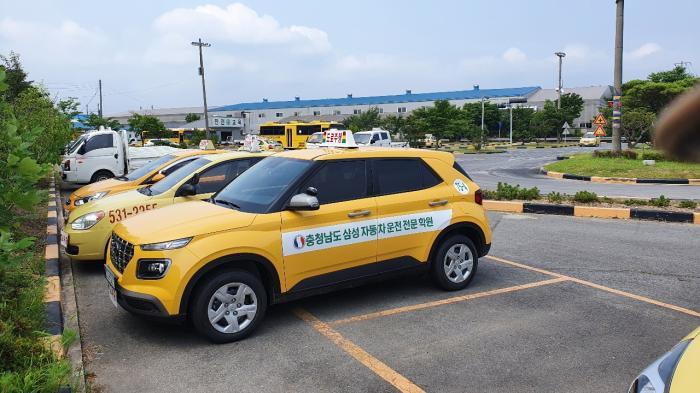 삼성운전면허학원 내부 전경, 깨끗한 시설과 교육용 차량들이 보인다.