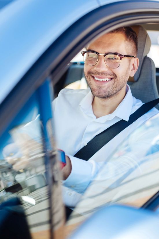 A person smiling after receiving their driver's license at the NJ DMV.