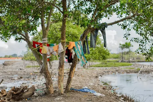Clothes hanging in open air at a Dhobi Ghat by the side of a river.