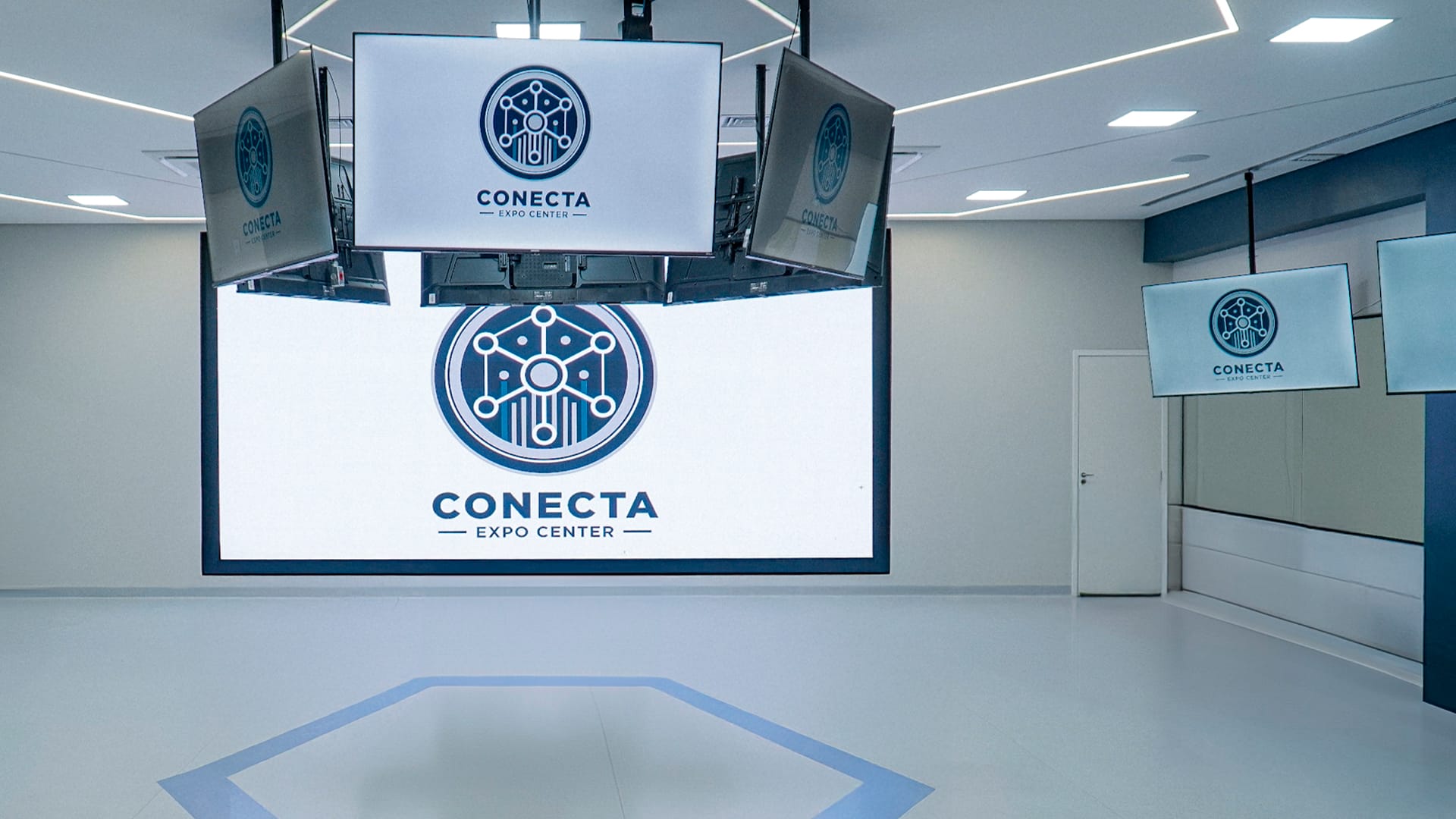 Sala do Conecta Training Center com o painel de LED e as TVs suspensas exibindo o logo do Conecta