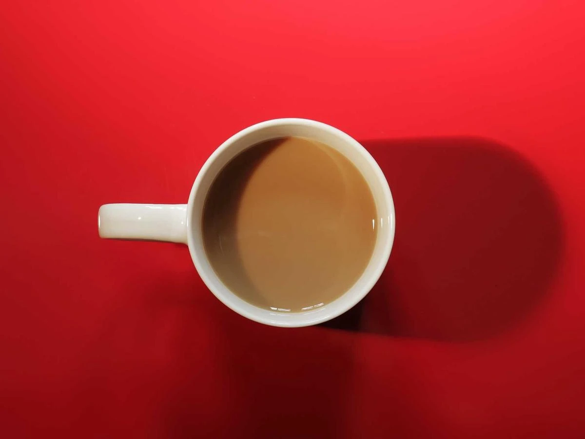 A cup of coffee on a bright red background