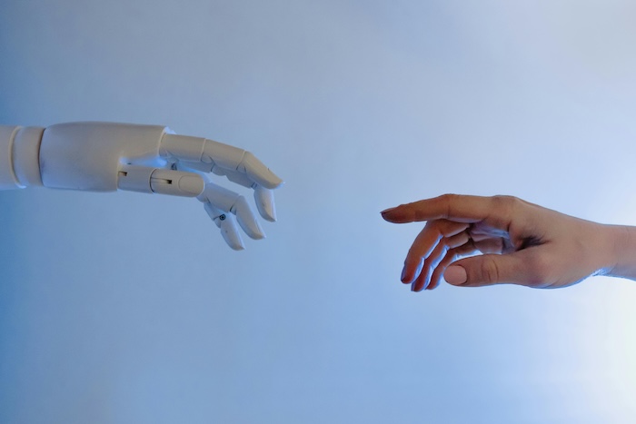 Human and robot hand reaching each other