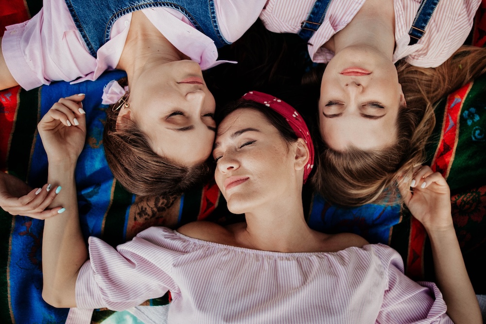 Three friends cuddling together, fully clothed