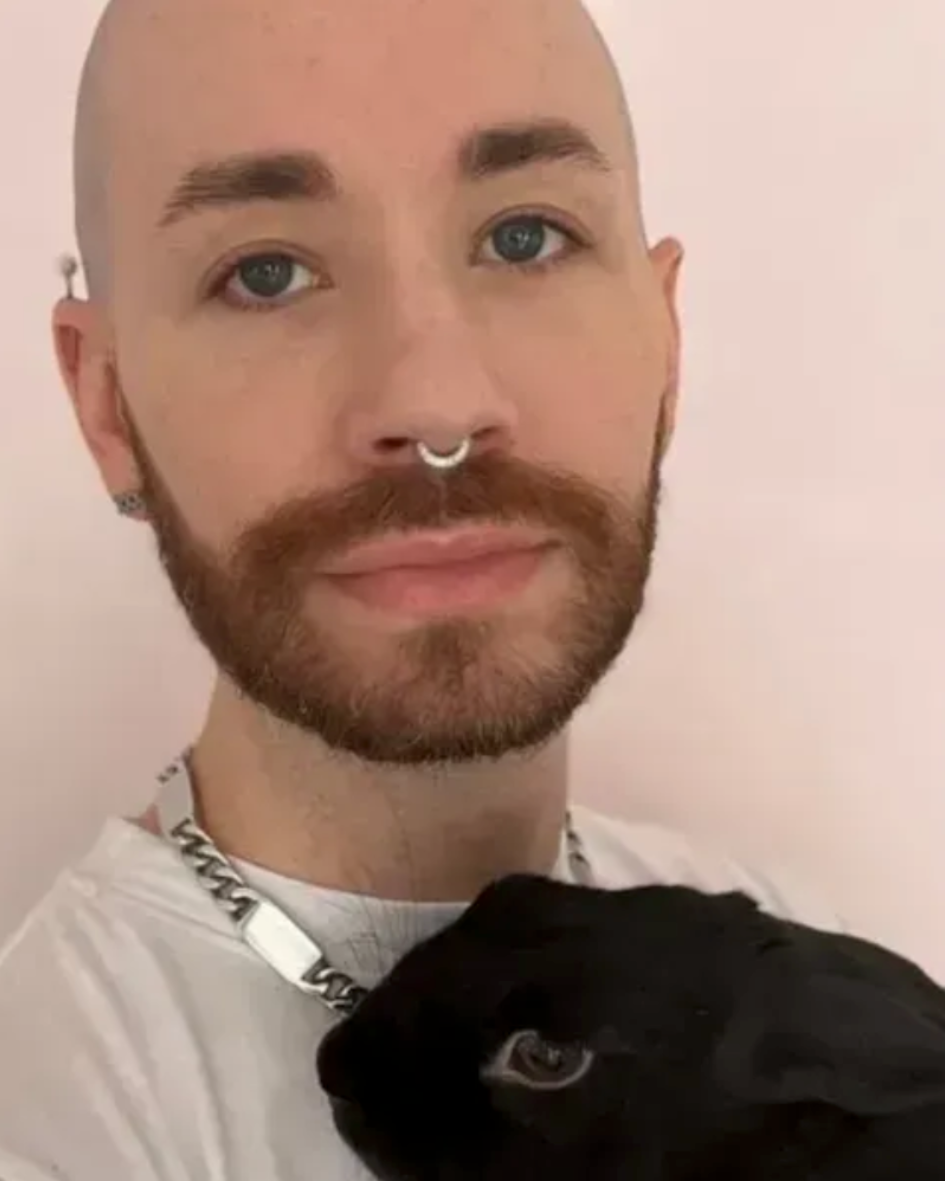 Jewels, a male cuddler in NYC, pictured with his black dog