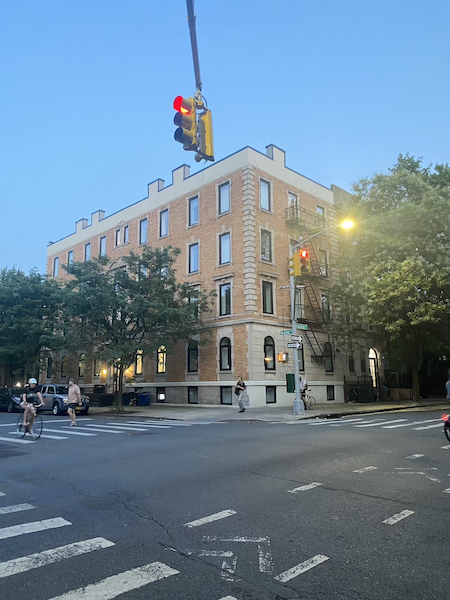 The corner building that houses the Embrace Club cuddle studio in Brooklyn, seen from across the street at dusk