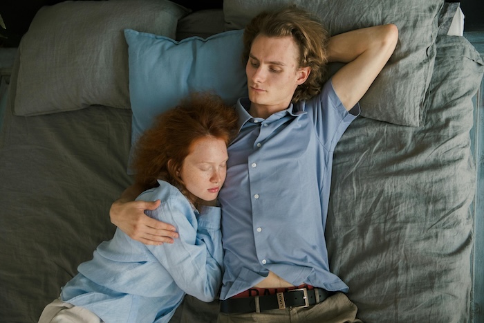 A man being hug by a woman