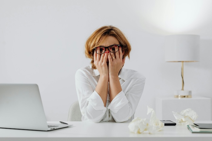 A woman holding her face feeling burnout