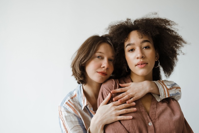 Two women in a warm, fully clothed embrace