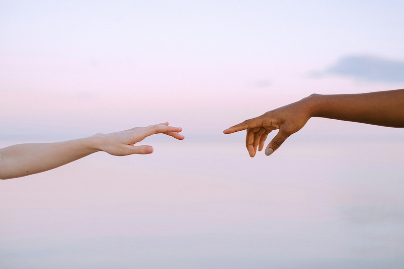 Two hands reaching each other