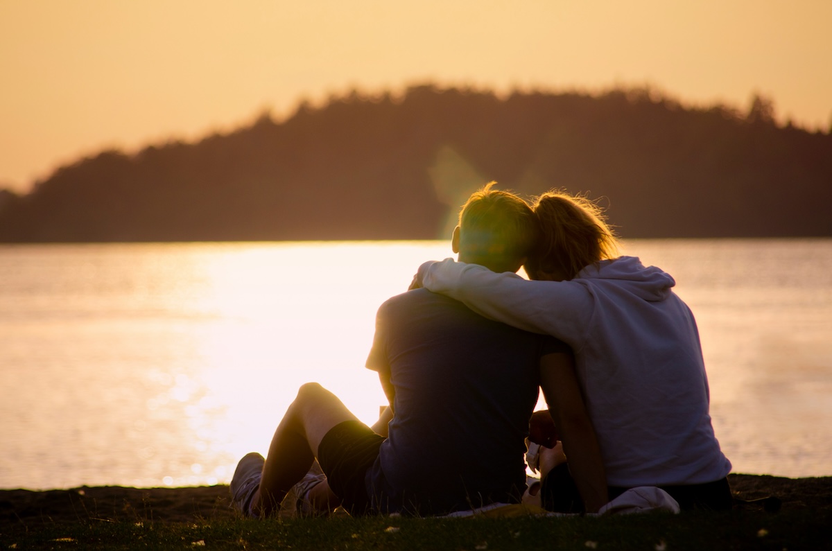 Two people hugging during sunset