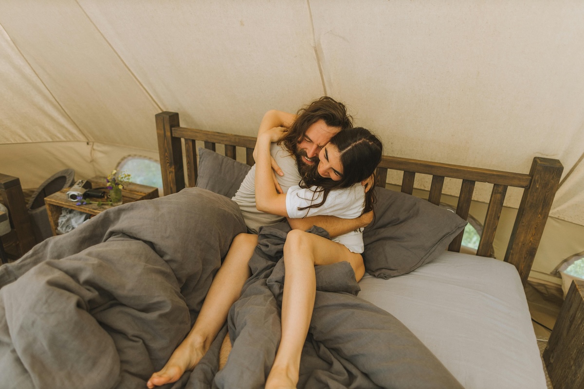 Two people hugging in bed