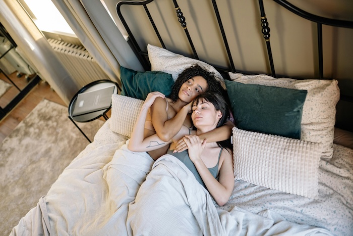 Two women cuddling in bed