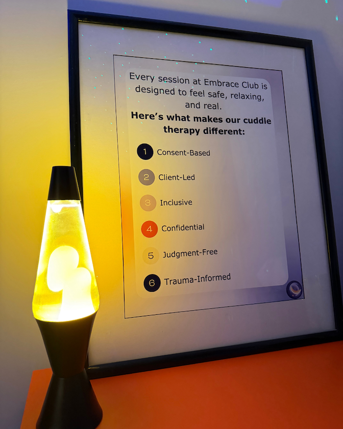 A framed sign in the studio listing the six principles, lit by a lava lamp