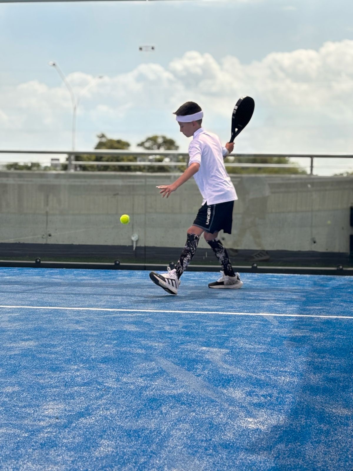 Two people playing padel on a blue court