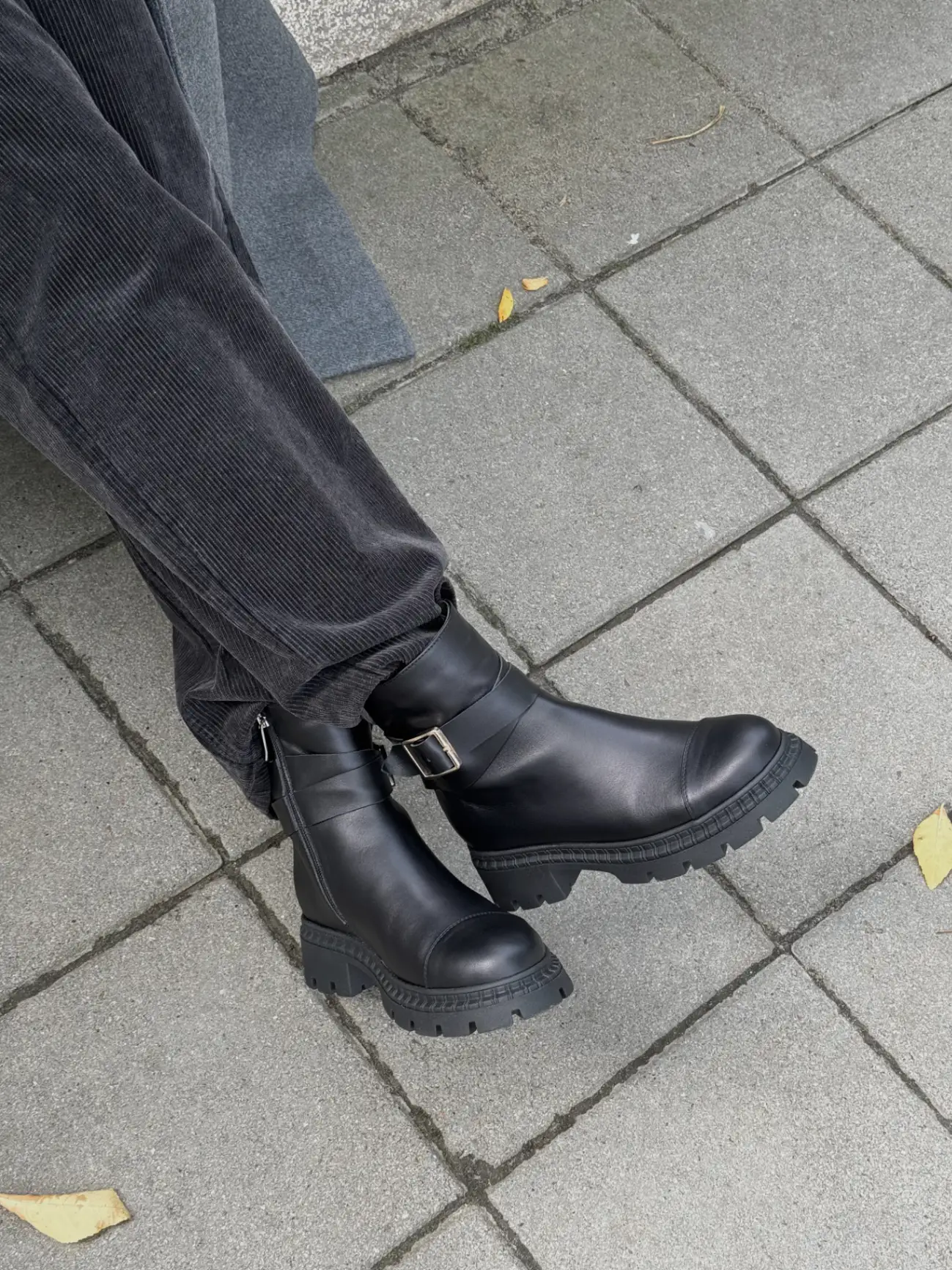 Black leather boots with zipper and strap lined with faux fur