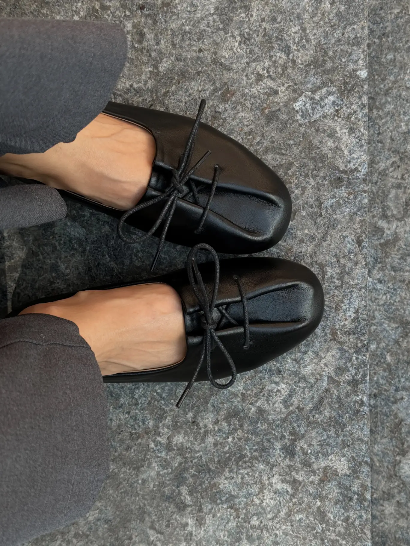Black leather round-toe ballet flats with a bow