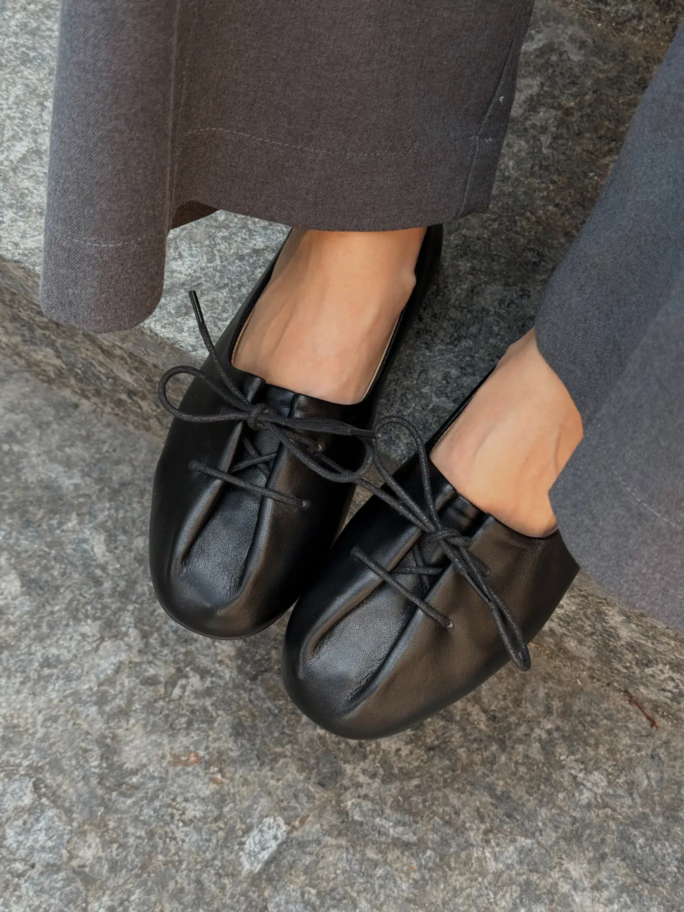 Black leather round-toe ballet flats with a bow