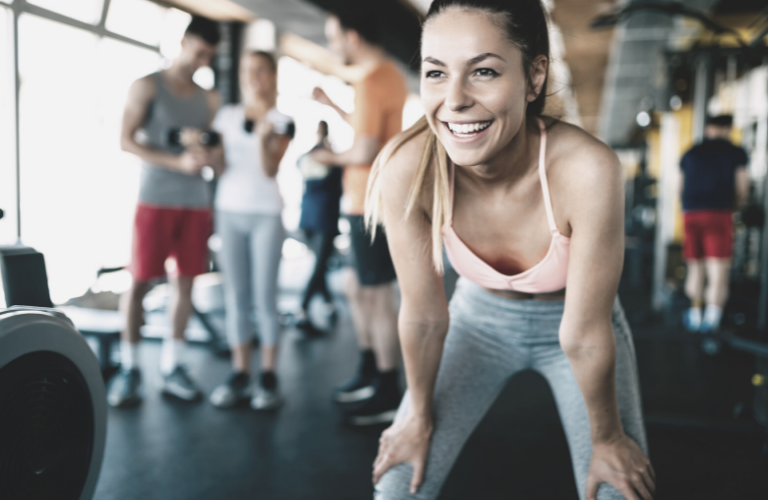 Frau im Fitnessstudio lebt betriebliche Gesundheitsförderung