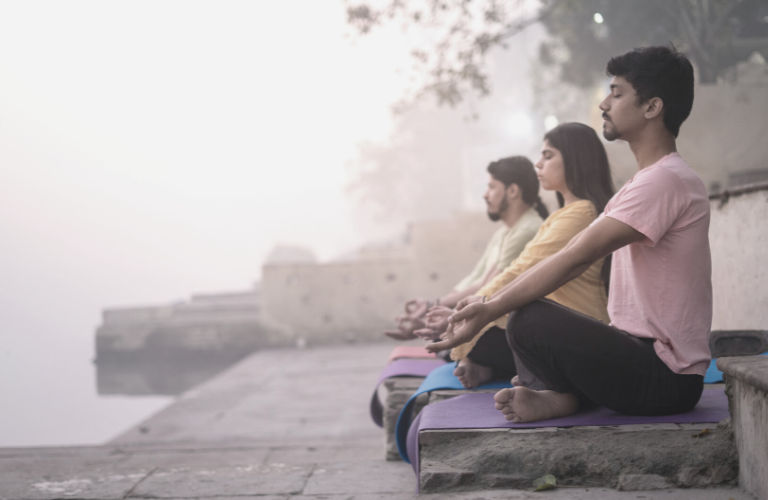 Drei Personen auf Bank in Breathwork Session