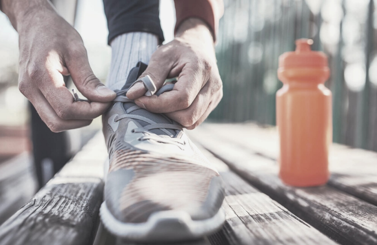 Was hilft gegen Stress - Laufschuhe werden gebunden