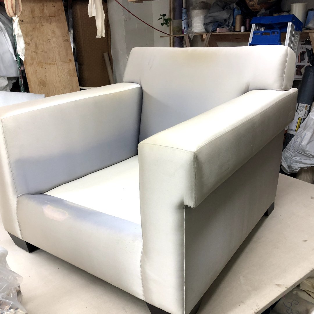 Bespoke custom-upholstered armchair in a textured cream fabric