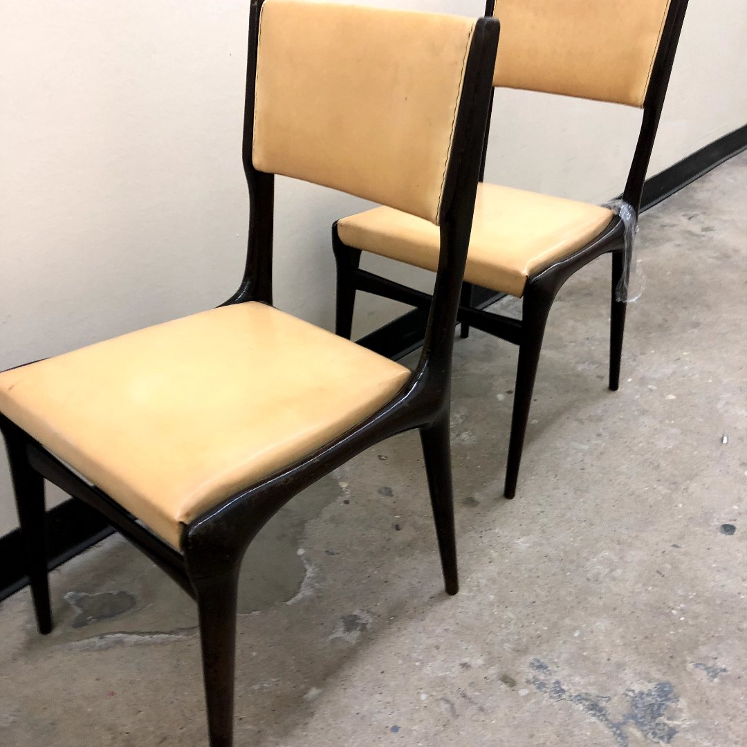 Mid-century modern dining chairs with custom leather upholstery and wood frames