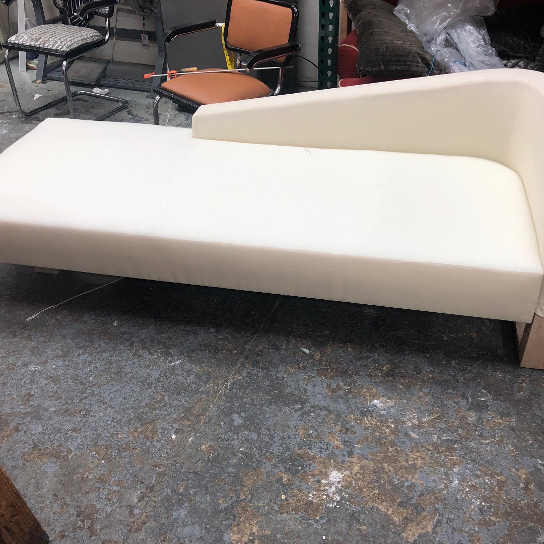 Contemporary chaise lounge with sleek gray upholstery and low-profile design.