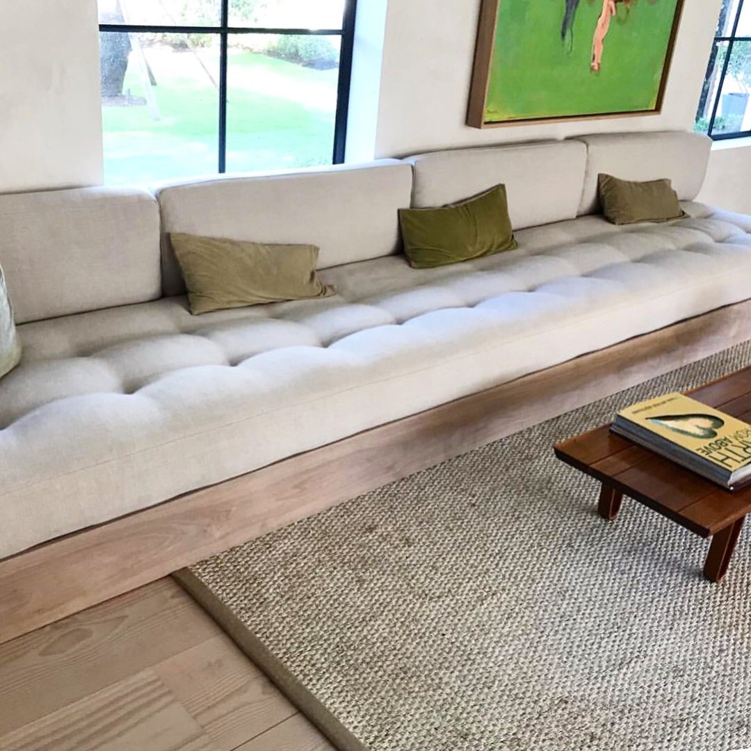 Long custom banquette seating with neutral upholstery and earth-tone cushions