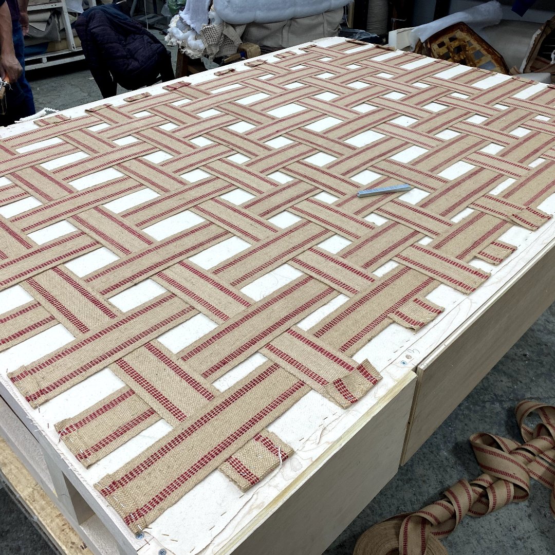 basket-weave pattern of jute webbing with thin red stripes