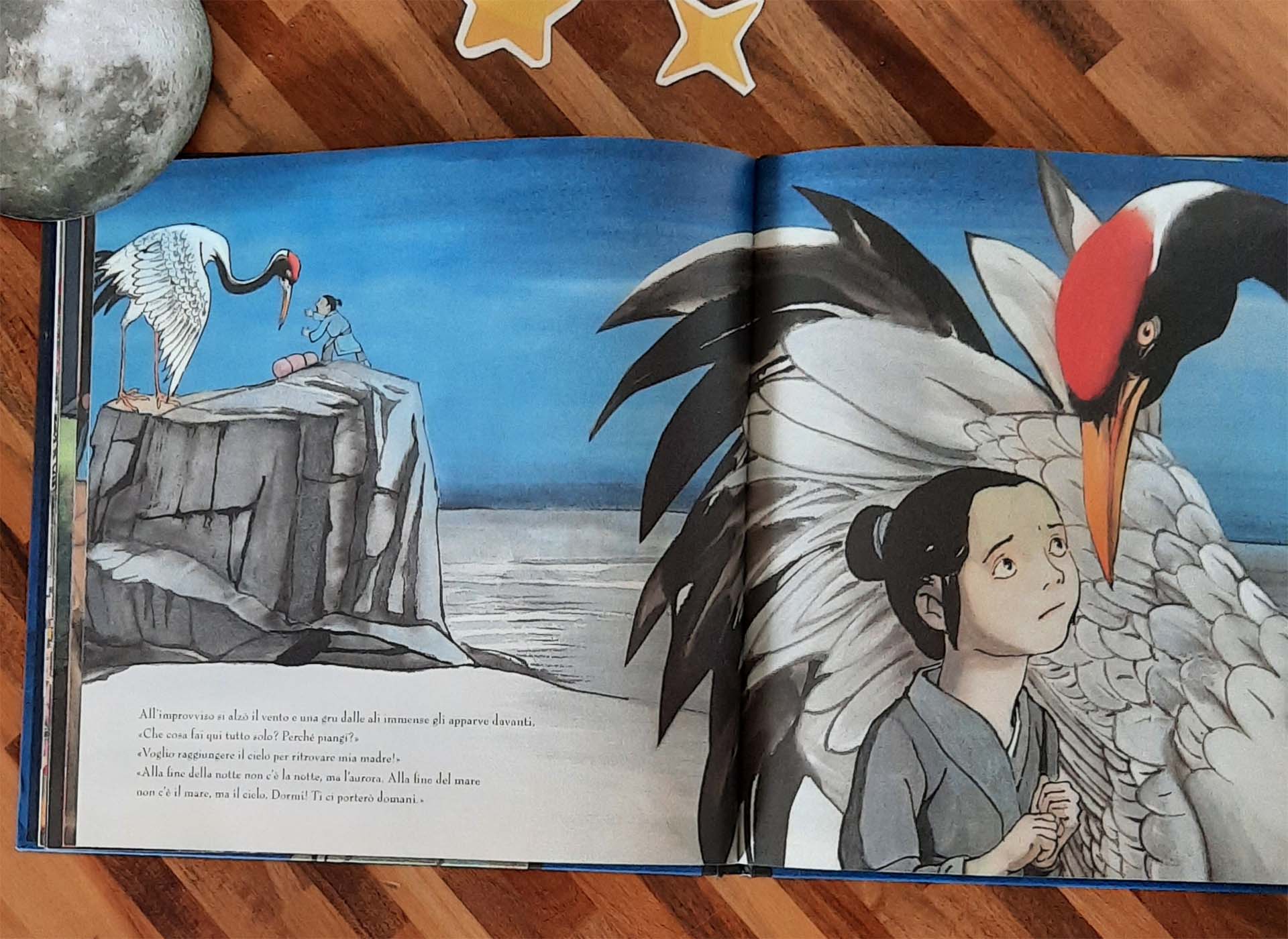 Doppia pagina blu: a sinistra, piccolissimi in cima a una scogliera sul mare, un bambino e una gru dalle ali spiegate; a destra la stessa gru in primissimo piano con il ciuffo rosso, e il bambino appoggiato alle sue piume