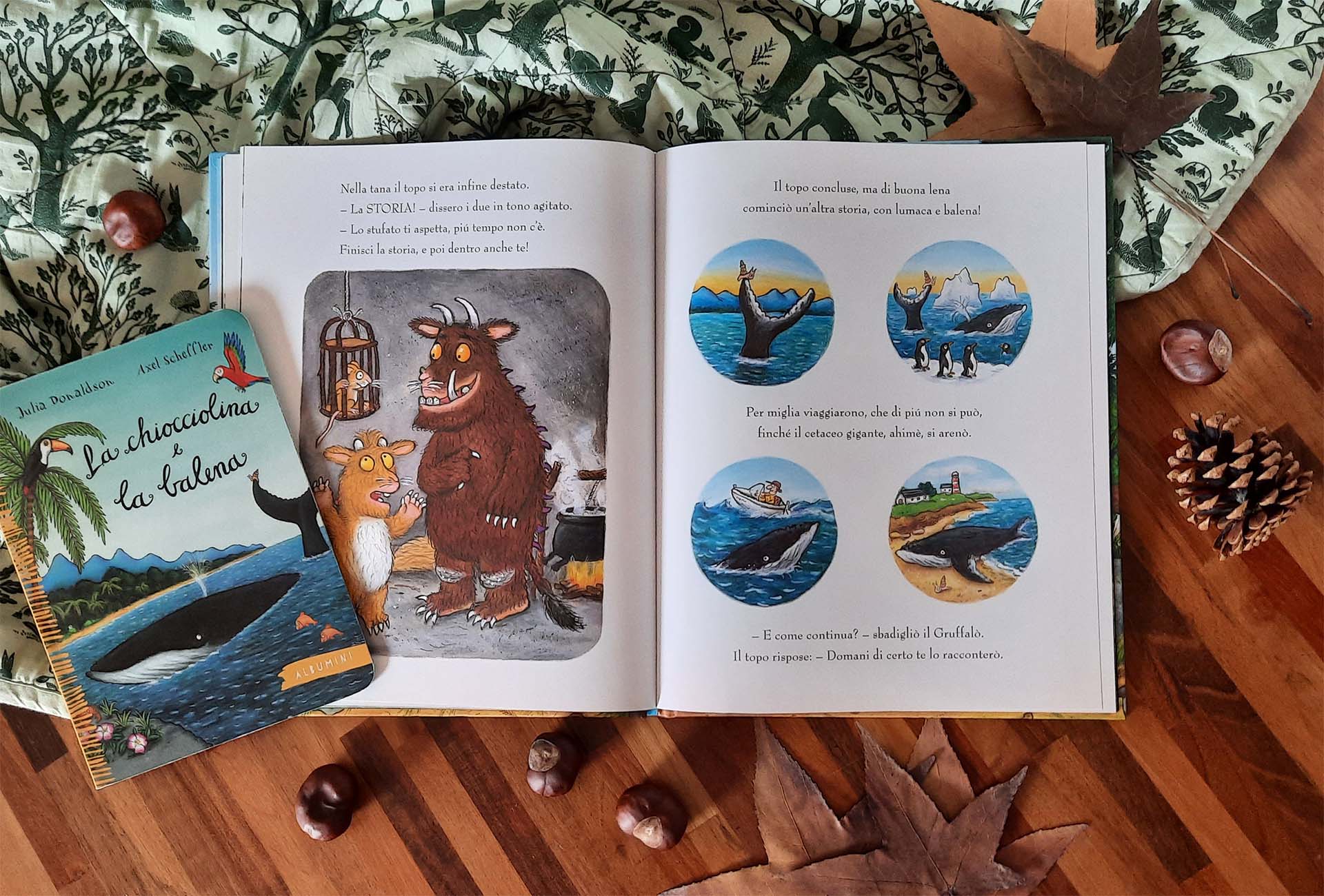 Doppia pagina: a sinistra il Gruffalò e la piccolina davanti alla gabbietta con il topo e il pentolone sul fuoco, a destra quattro tondi con una balena, pinguini e una barca. Accanto al libro, l'albumino de La chiocciolina e la balena