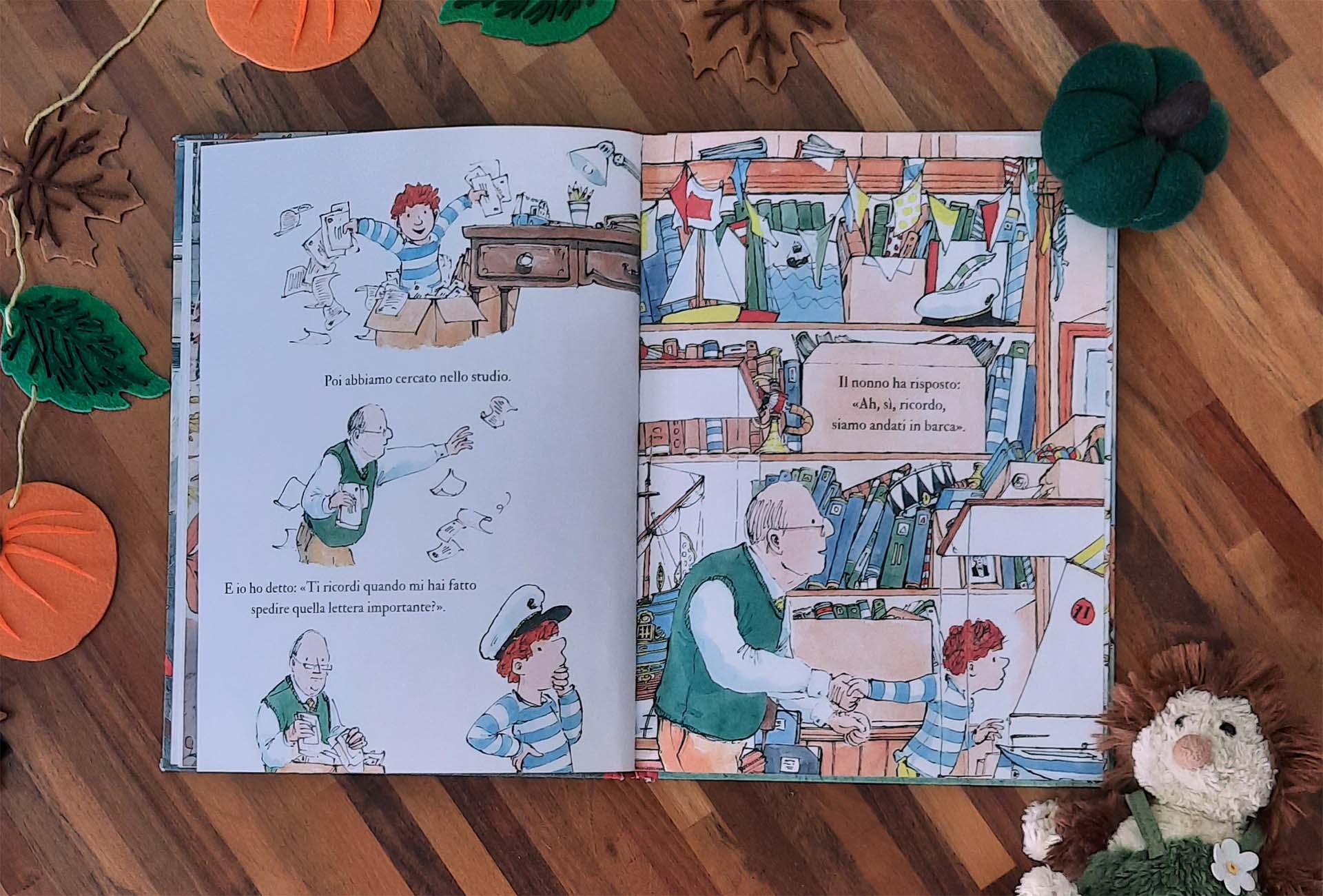 Doppia pagina: a sinistra il bambino rovescia una scatola di carte nello studio, a destra scaffali stipati di libri, bandierine e un veliero giocattolo