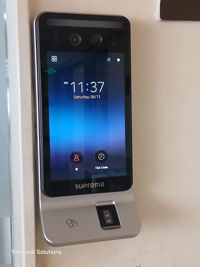 Suprema face recognition and fingerprint access control terminal mounted beside an office door