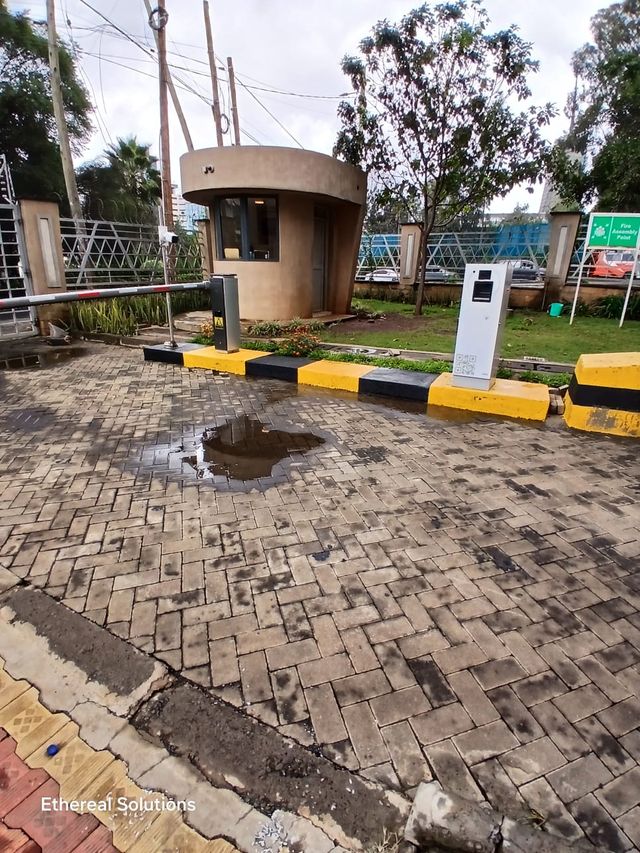 Boom barrier, parking ticket terminal and guard house at a controlled vehicle entrance
