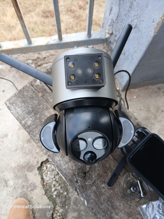 Dual-lens PTZ security camera with floodlights and Wi-Fi antennas being set up on site