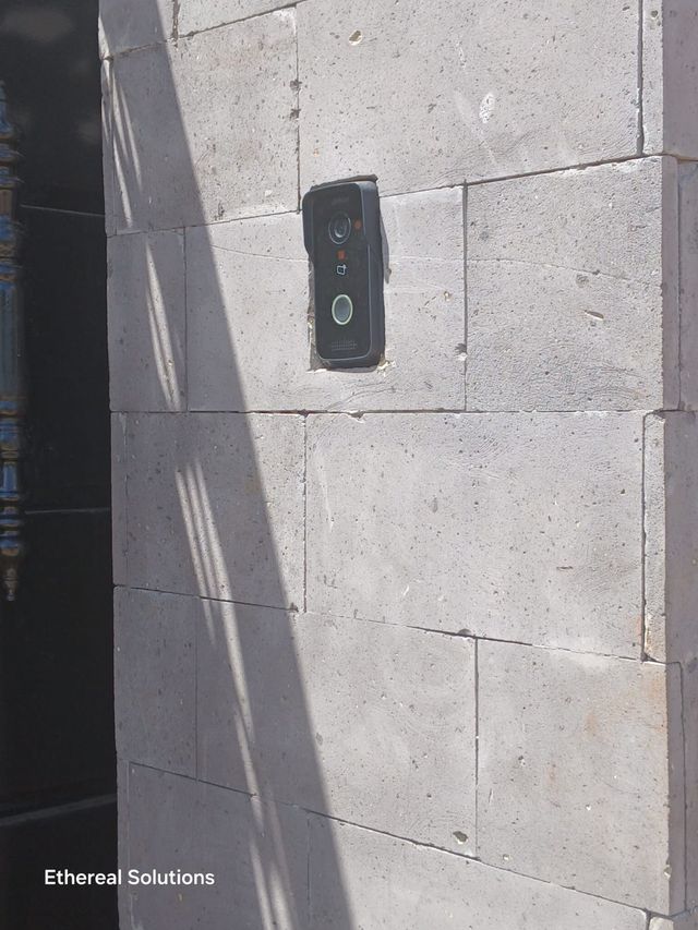 Dahua video doorbell recessed into a stone gate pillar at a residential entrance
