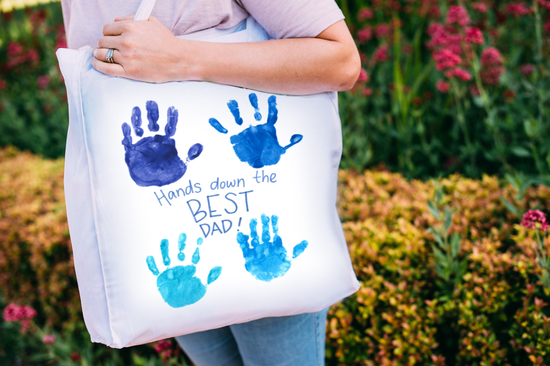 Parent proudly displaying their childs personalised tote bag fundraising designs