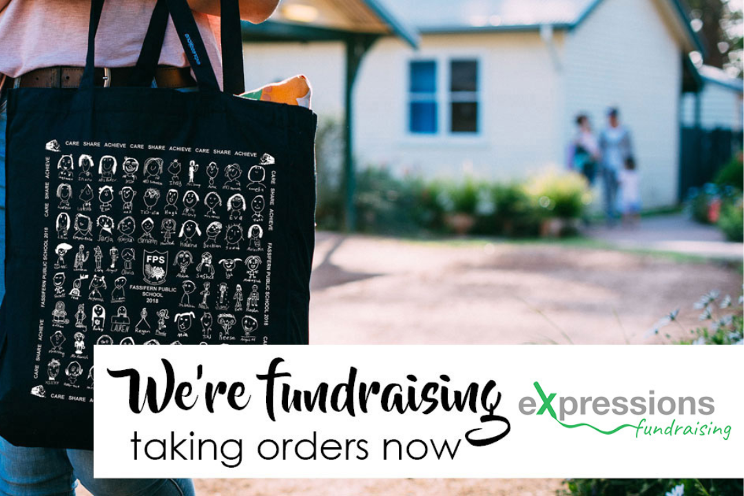 Close-up of a black tote bag featuring children’s portrait drawings, held outside a school building with 'We’re fundraising – taking orders now' text overlay.