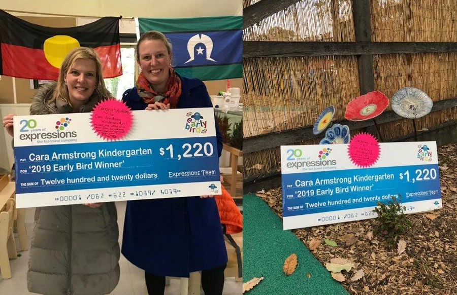 Two smiling women holding a large cheque from Expressions Fundraising awarding $1220 to Cara Armstrong Kindergarten for their Early Bird tea towel fundraiser win.