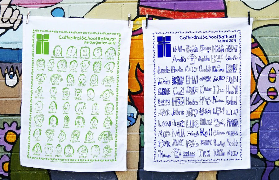 Two Cathedral School Bathurst tea towels featuring student artwork and names as part of a school fundraising project.