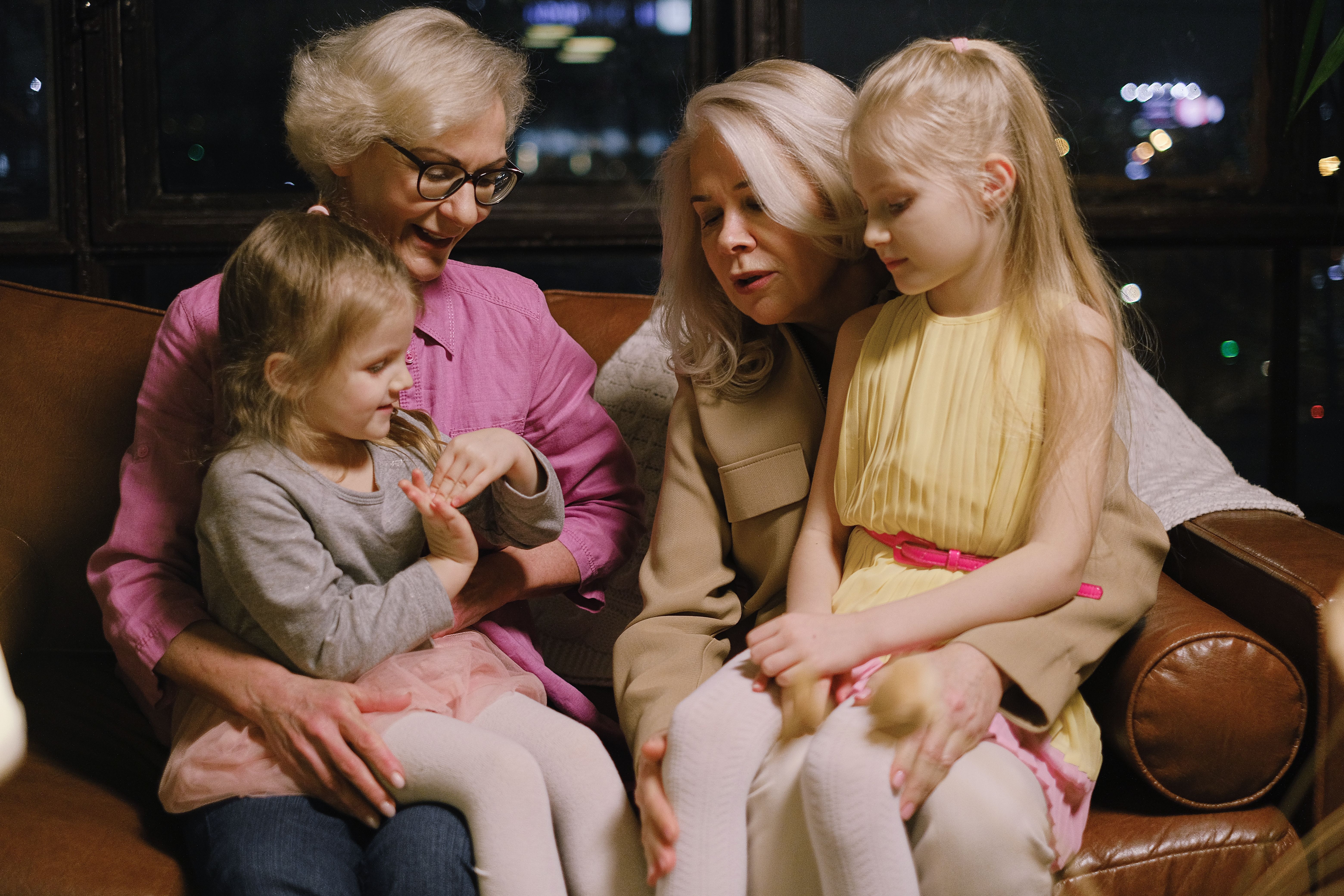 Two grandmothers sharing a warm moment with their granddaughters