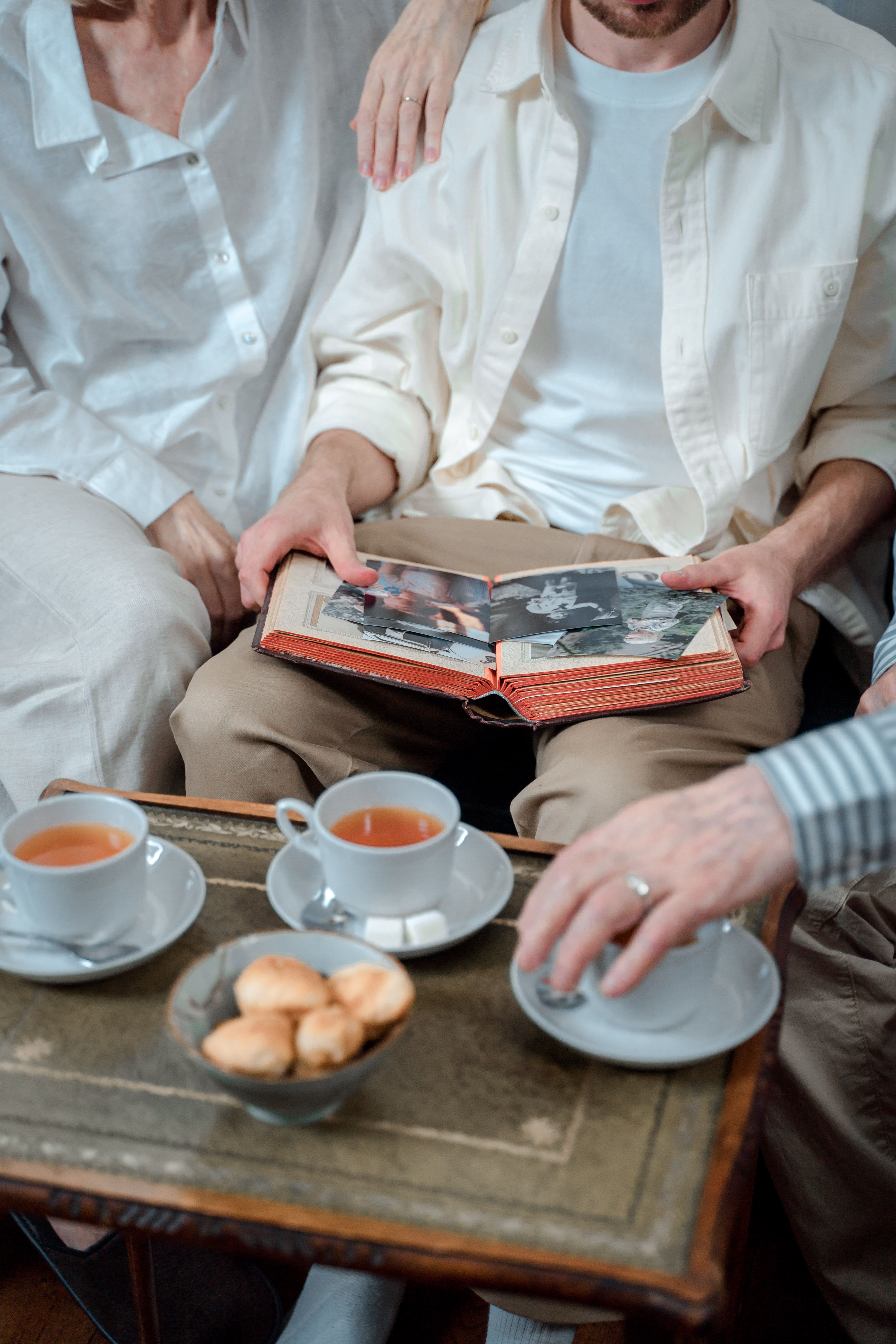 A family looking through an old photo album together over tea