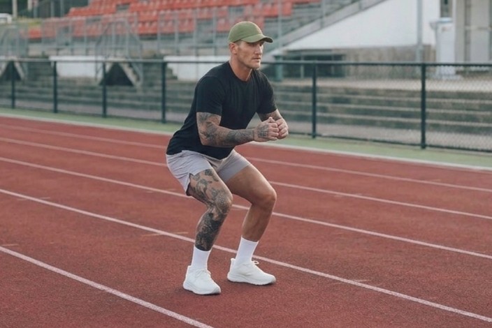 Runner landing a bounding jump, absorbing impact in a shallow squat
