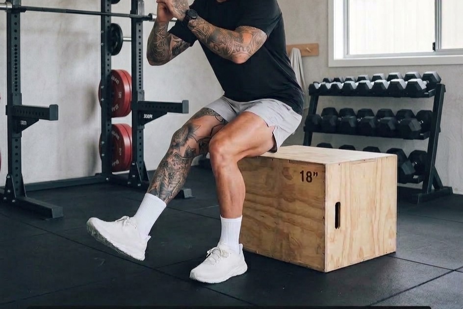 Runner performing a single-leg squat, lowering toward a chair with knee tracking over the toes